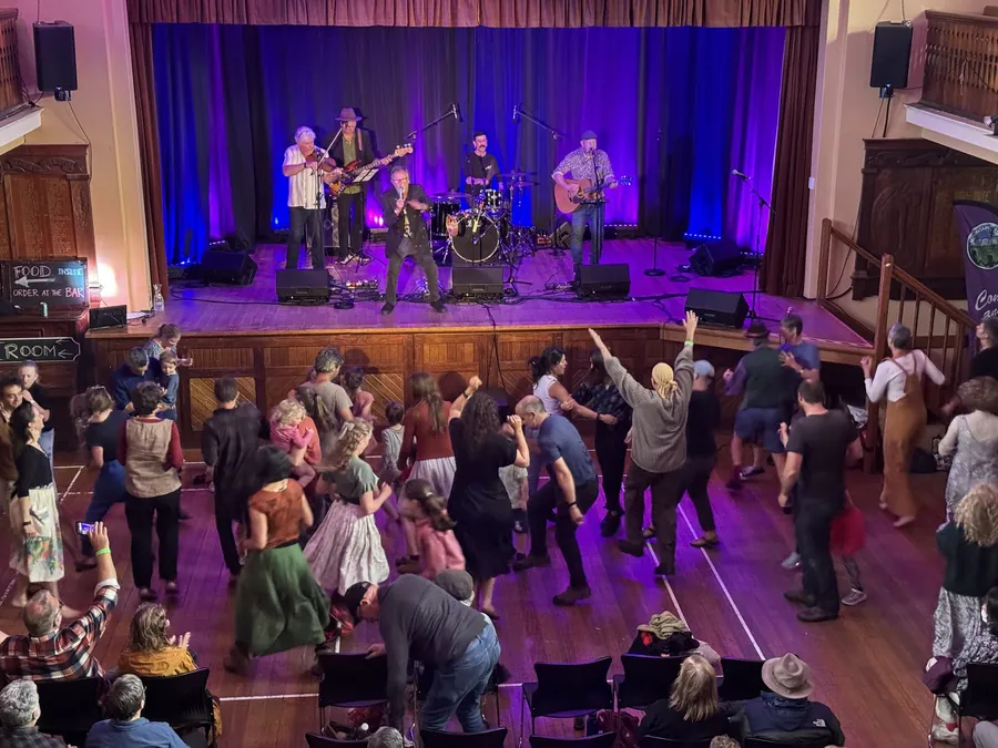 Festival-goers dancing in front of a live band at Sheffield Town Hall