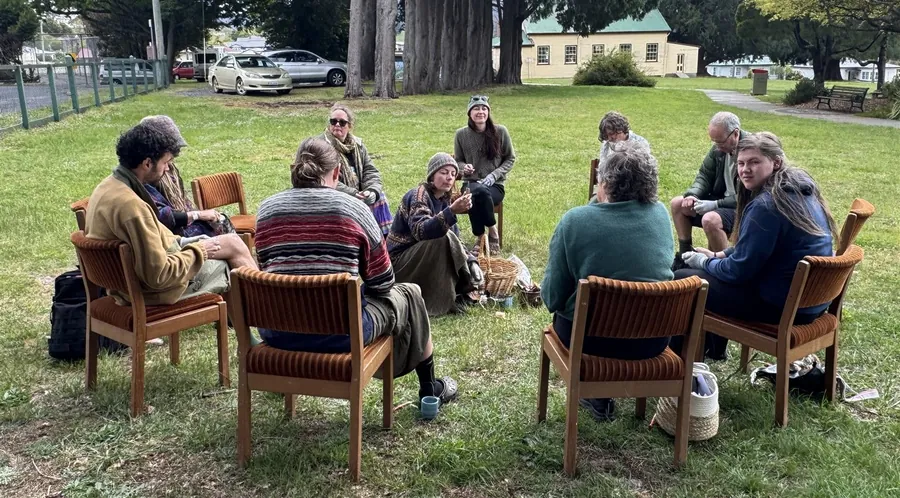 Festival-goers sitting in a circle and learning together outdoors