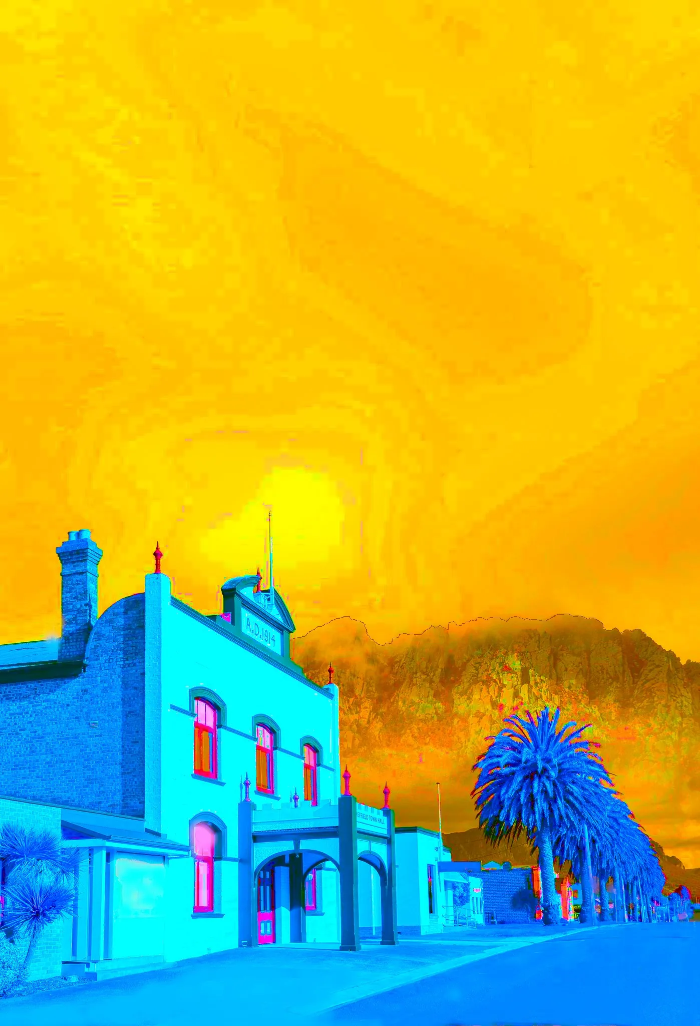 Vivid yellow-and-blue view of Sheffield Town Hall beneath Tarinimari / Mount Roland